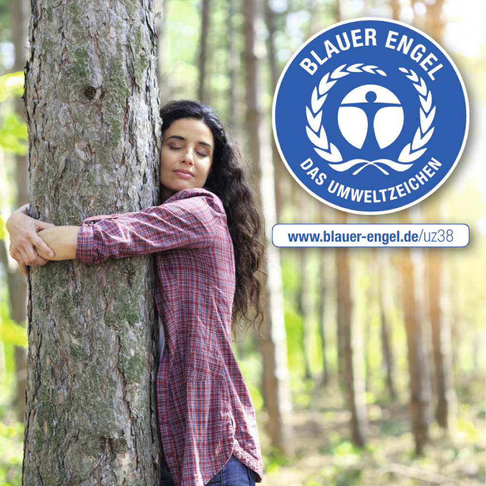 Junge Frau umarmt einen Baum im Wald. Das Label "Blauer Engel" ist abgebildet.