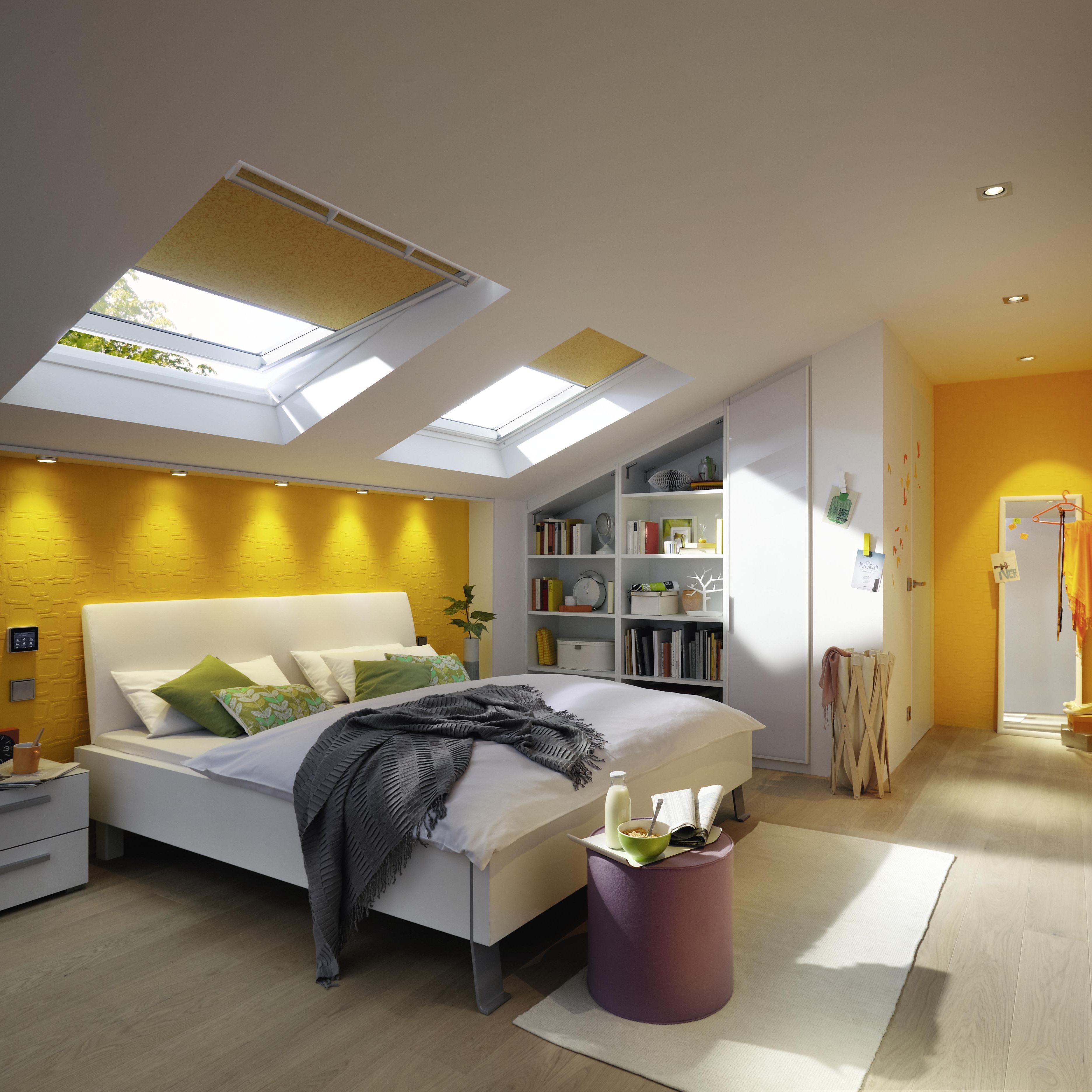 Das weiße Schlafzimmer unter dem Dach mit farbigen Akzenten in Gelb wirkt hell und freundlich.