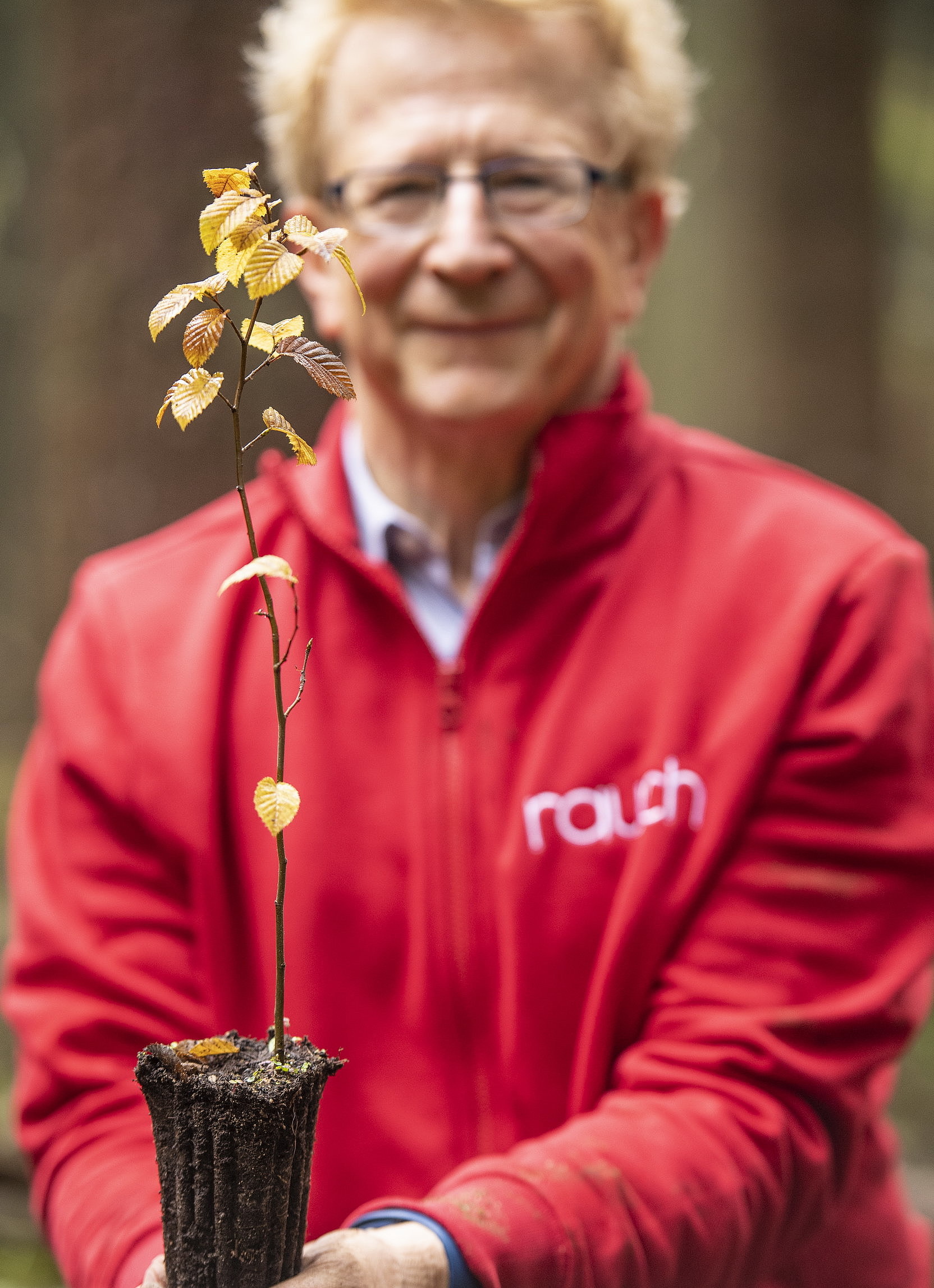 Michael Stiehl hält schützend einen Baumsetzling in den Händen.