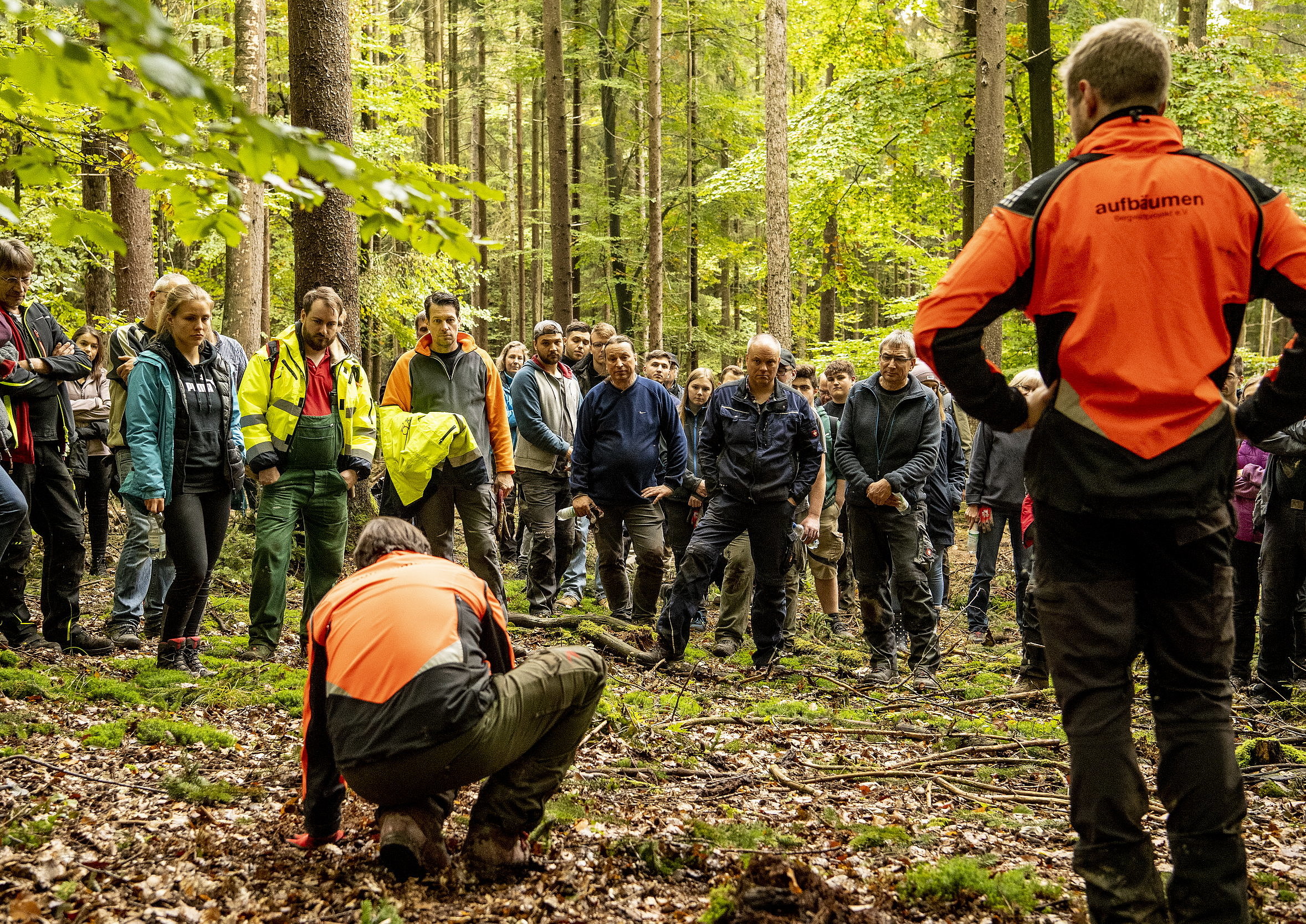 Zwei Mitarbeiter des Bergwaldprojektes erklären den Unterstützern das Setzen der Bäume.