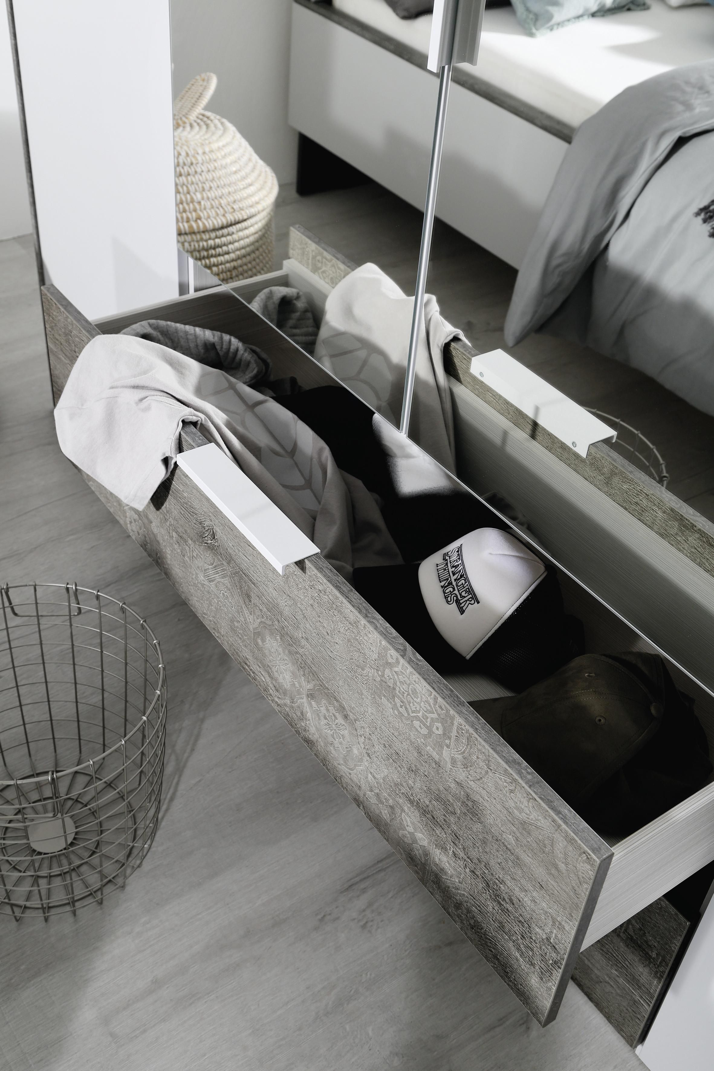 Ein Kleiderschrank mit Schubladen bietet viel Stauraum für Klamotten, Kappen und mehr.